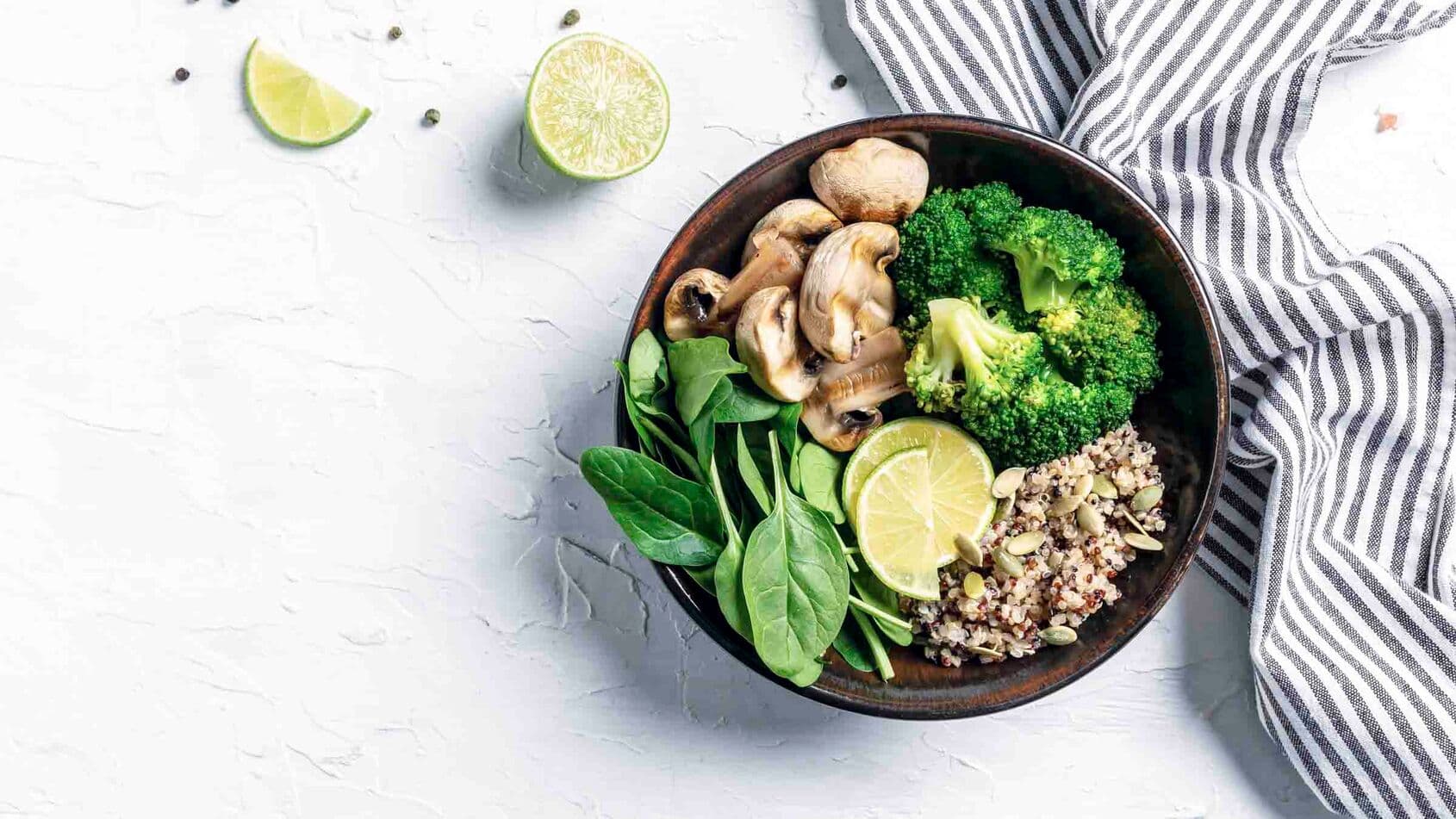 Diet salad made from fresh vegetables broccoli, mushrooms, spinach and quinoa in a bowl. Delicious breakfast or snack, Clean eating, dieting, vegan food concept. top view.