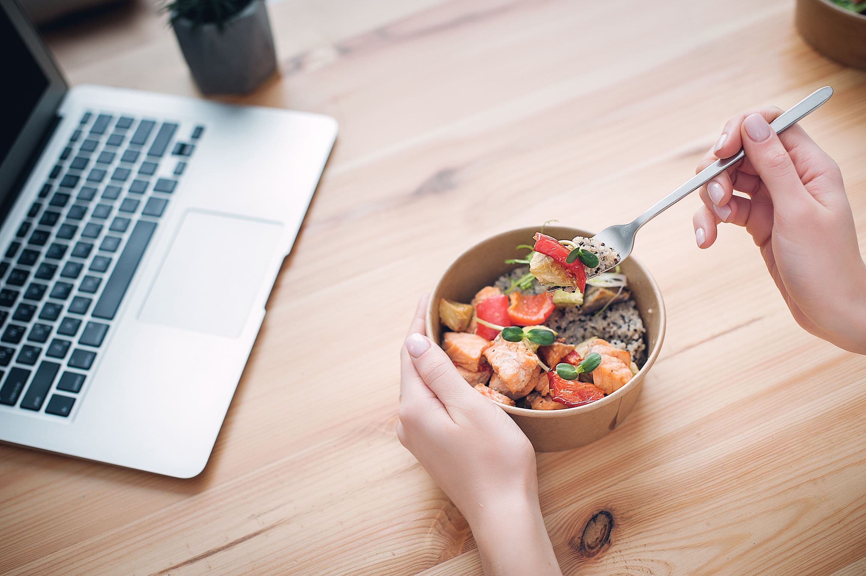 A woman has lunch and works at home. Close-up. Top view. Space for text in the smartphone